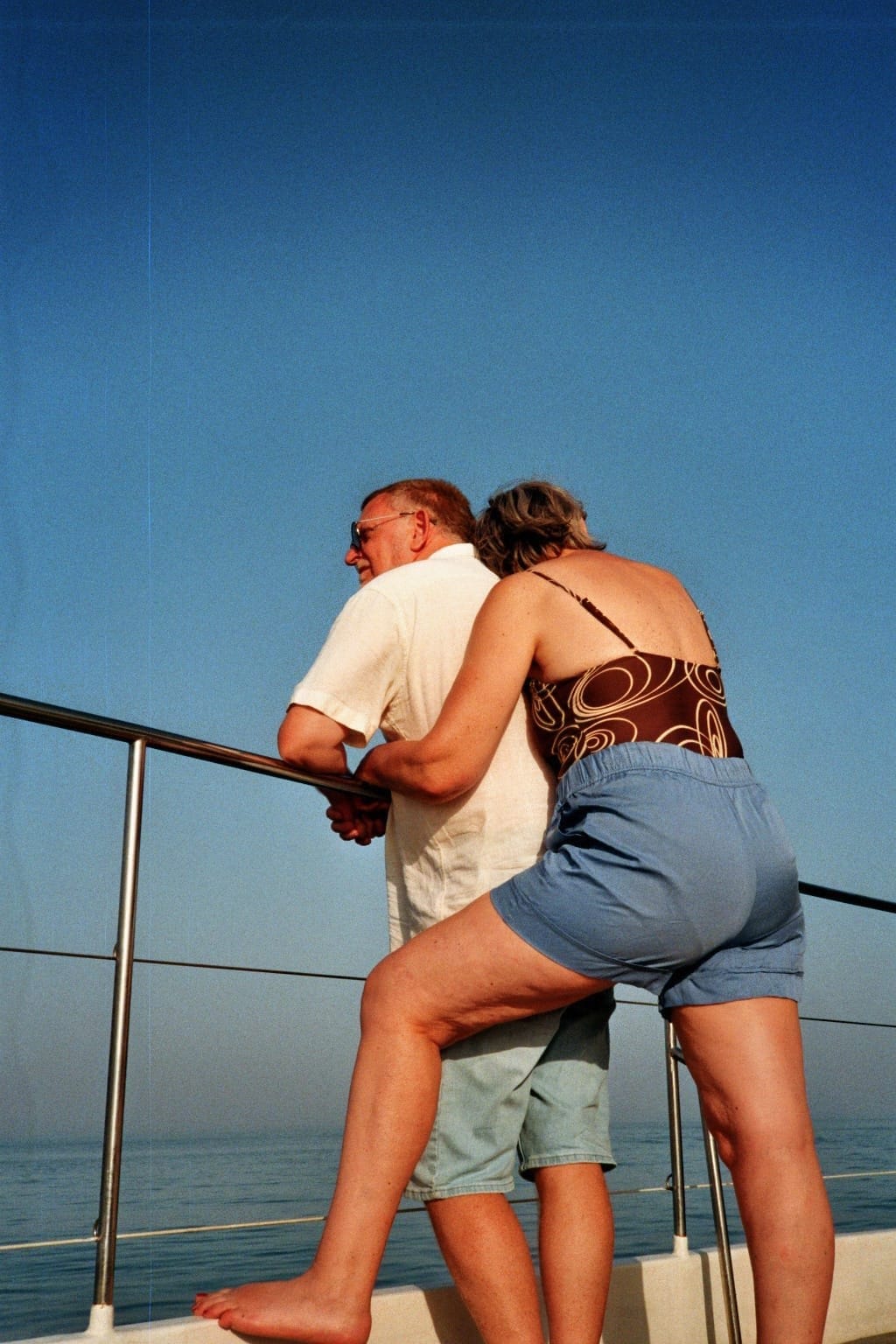Film photo: a couple at the railing of a boat
