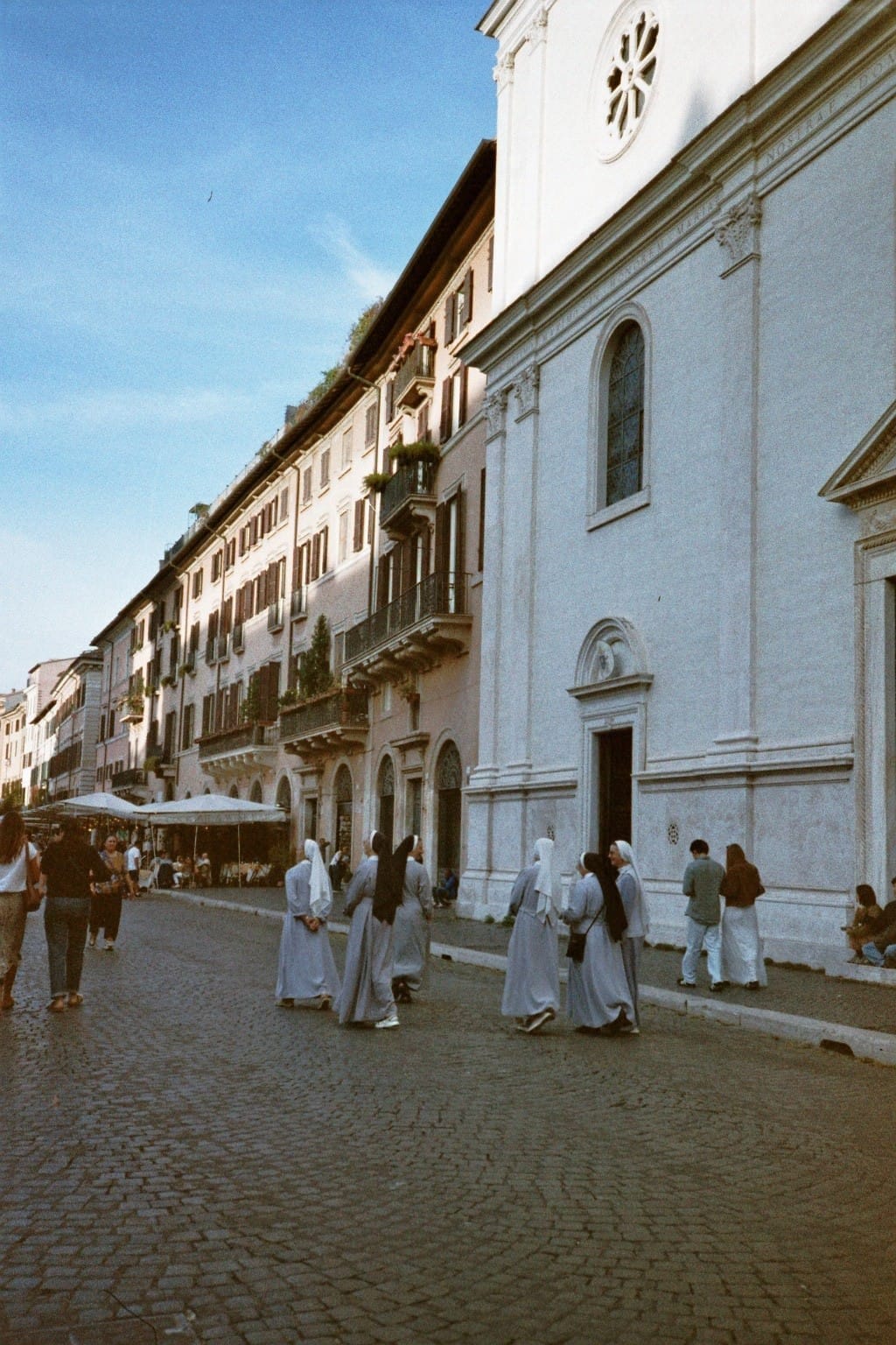 Film photo: nuns walking past a church in Rome