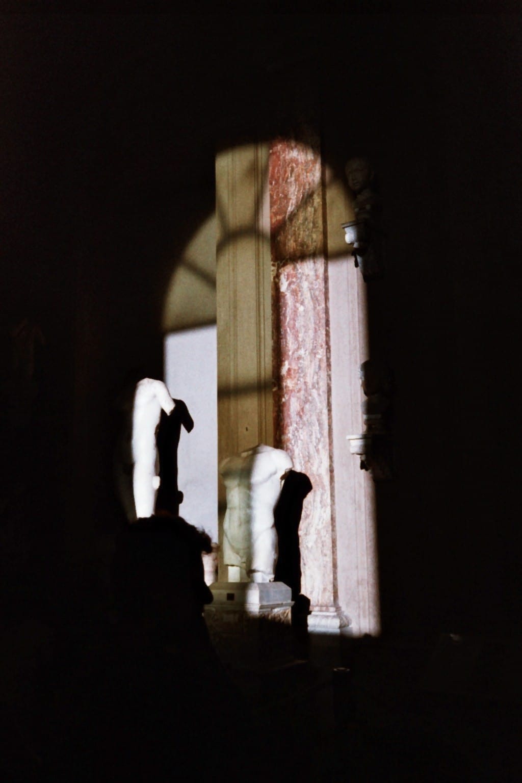 Film photo: marble statues in a beam of light in a museum